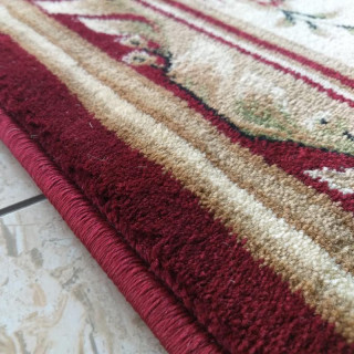 Metrážny koberec v červenej farbe s ornamentom