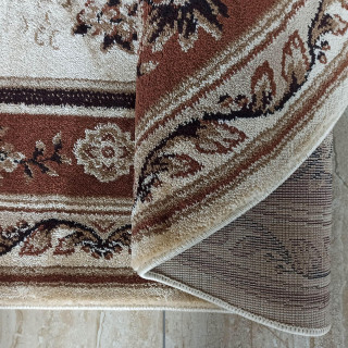 Hnedý oválny koberec so vzorom